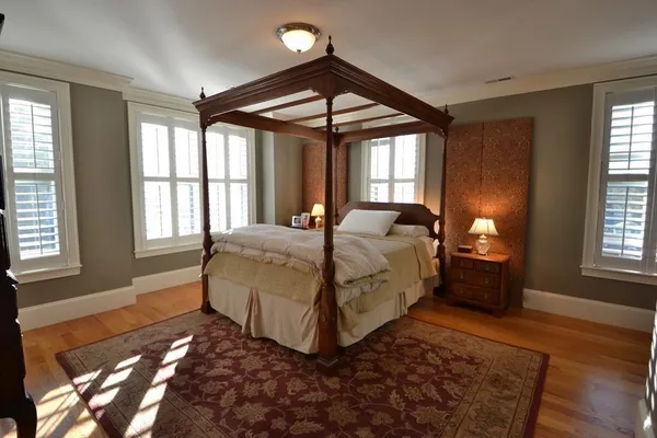 a bedroom with a bed lamp closet and large window
