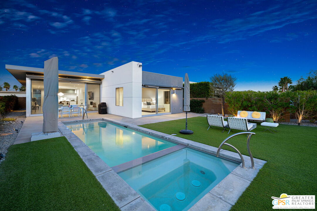 a view of a house with swimming pool and sitting area