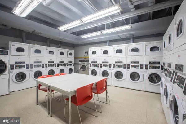 a utility room with stainless steel appliances a stove a sink and a refrigerator