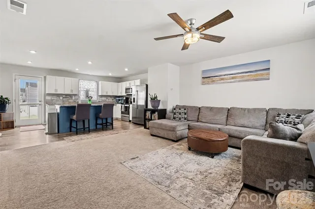 a living room with furniture and kitchen view