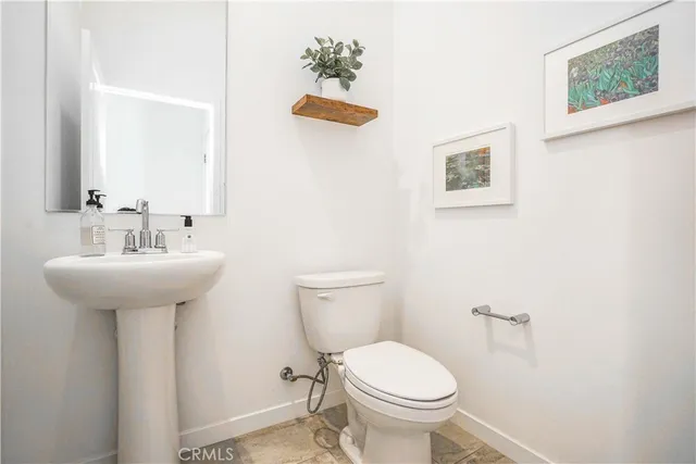 a bathroom with a sink mirror and toilet