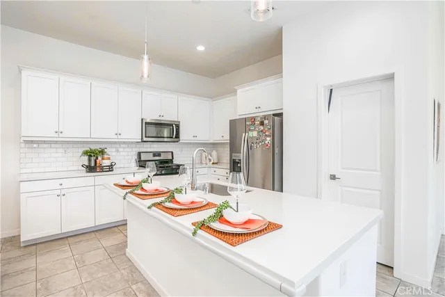 a kitchen with stainless steel appliances granite countertop a sink and a refrigerator