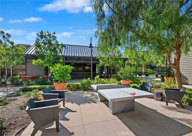 a view of a patio with couches table and chairs and potted plants