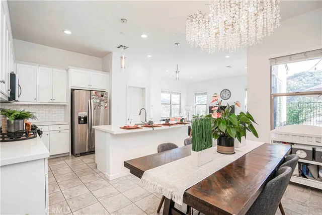 a kitchen with refrigerator and chairs