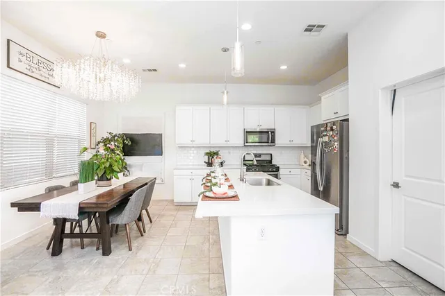 a kitchen with a dining table chairs refrigerator and microwave