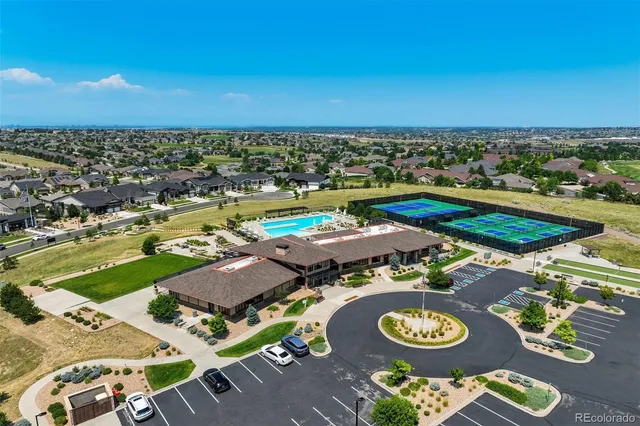 an aerial view of a residential houses with outdoor space and trees