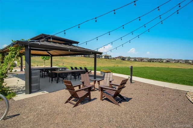 a view of swimming pool with lawn chairs and a big yard