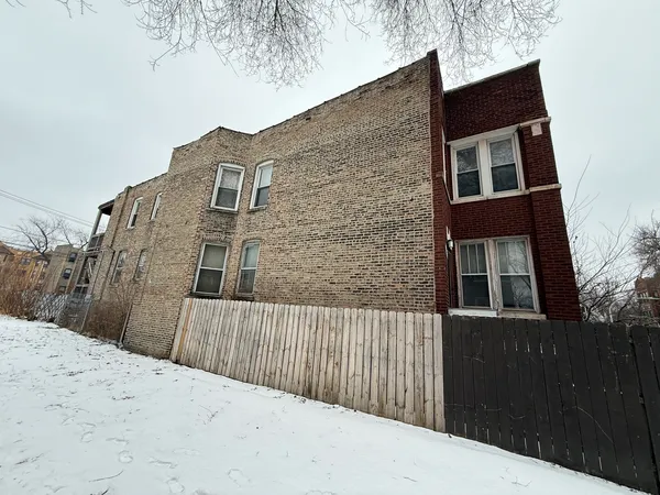 a view of a house with a wooden fence