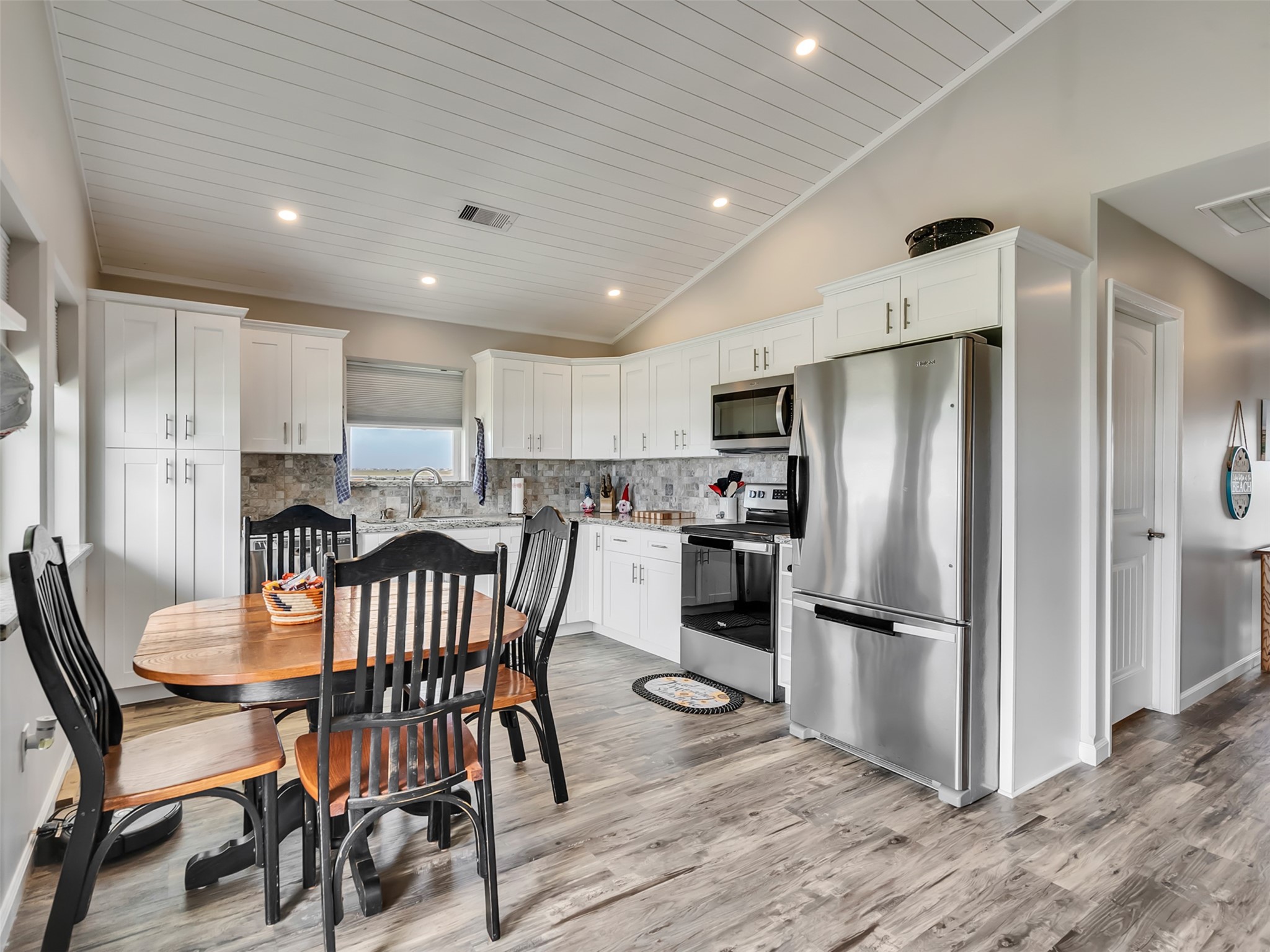 1453 County Road 230 Sargent, TX 77414 - Photo 12 of 38 This photo showcases a modern kitchen with sleek stainless steel appliances, and white cabinetry and water views from every window