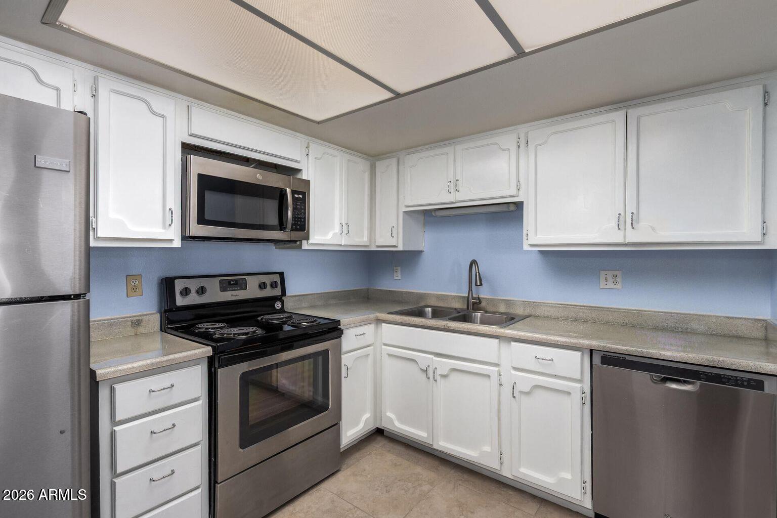 7950 East Camelback Road, Unit 28205 Scottsdale, AZ 85251 - Photo 6 of 23 a kitchen with cabinets stainless steel appliances and wooden cabinets