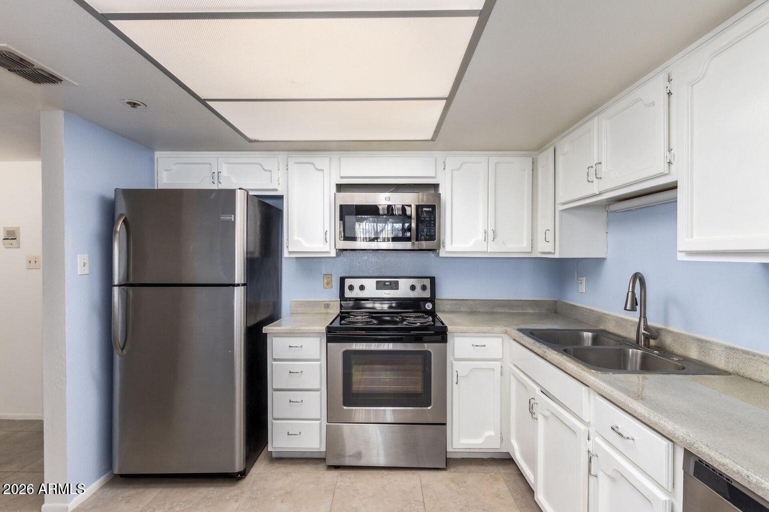 7950 East Camelback Road, Unit 28205 Scottsdale, AZ 85251 - Photo 8 of 23 a kitchen with a refrigerator sink and cabinets