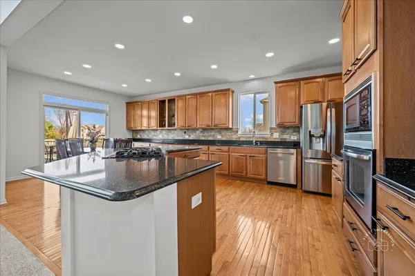 a kitchen with stainless steel appliances granite countertop a sink a stove and a refrigerator