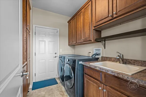 a utility room with granite countertop a sink a washer and dryer