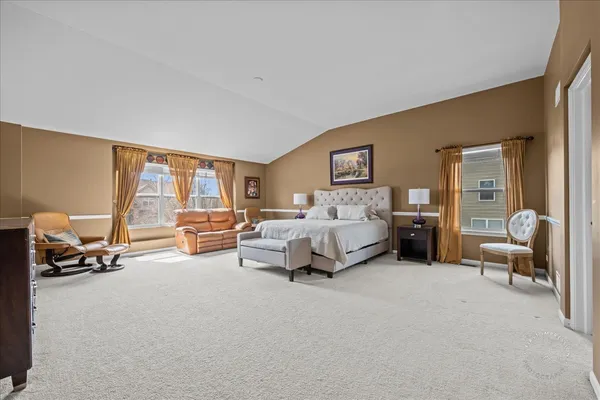 a bedroom with furniture and a large window with couch