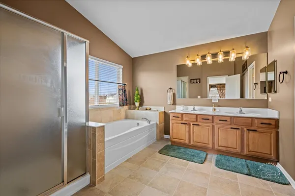 a spacious bathroom with a tub sink and mirror