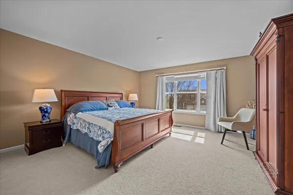 a spacious bedroom with a bed and a lamp with window