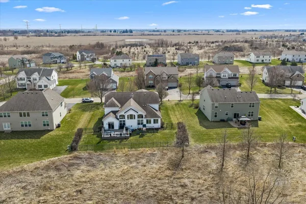 an aerial view of a house with a garden and lake view