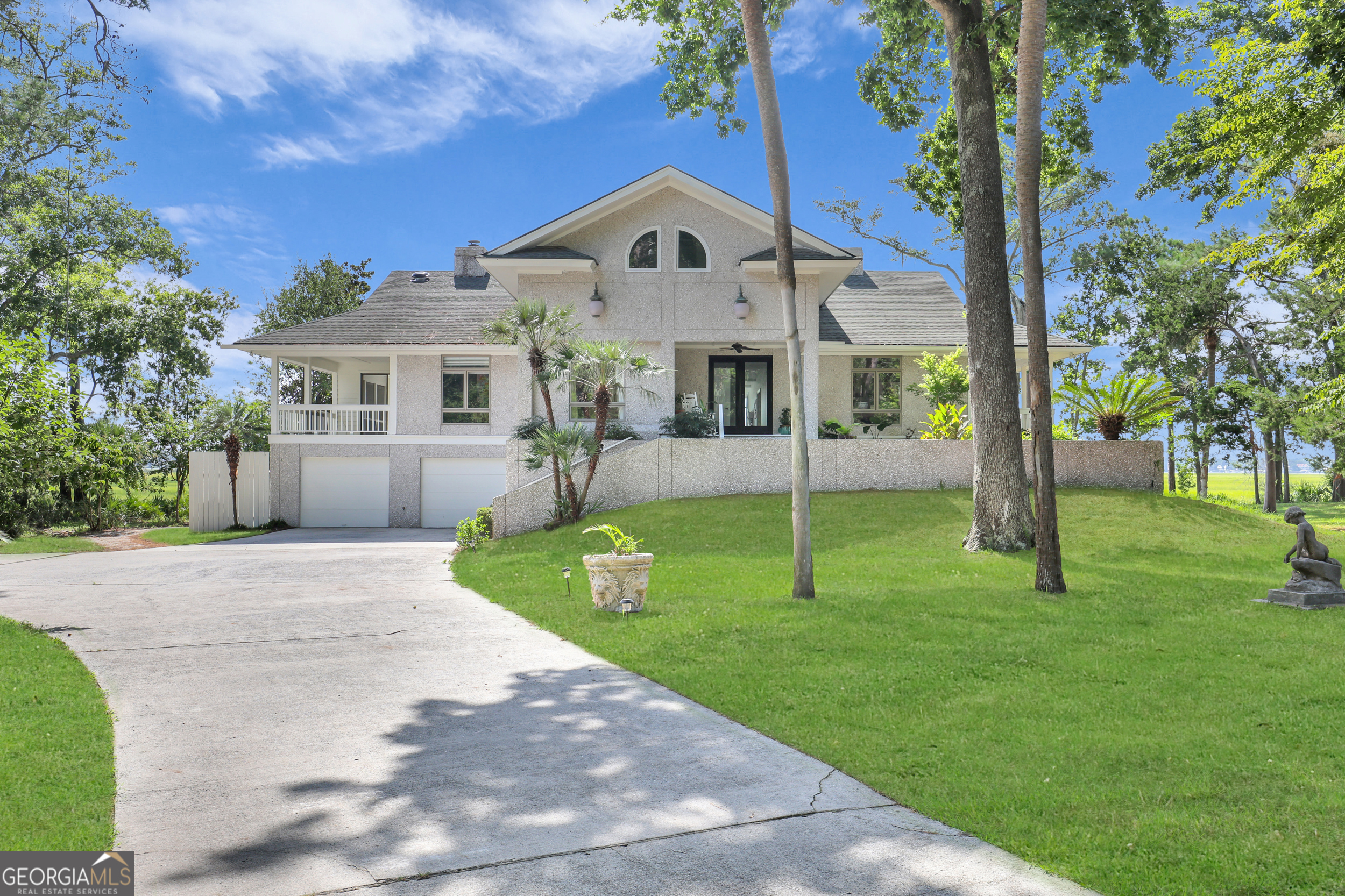 a front view of a house with a yard and potted plants