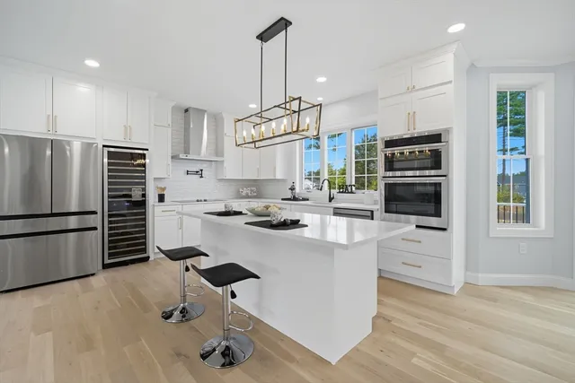 a kitchen with kitchen island a stove a refrigerator and a oven with wooden floor