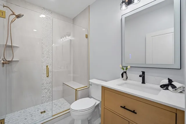 a bathroom with a sink a toilet and shower