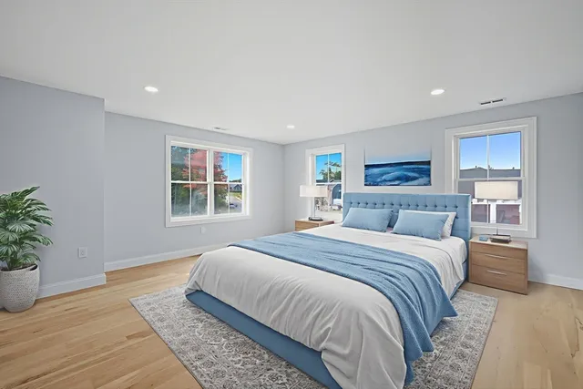 a spacious bedroom with a large bed and a potted plant