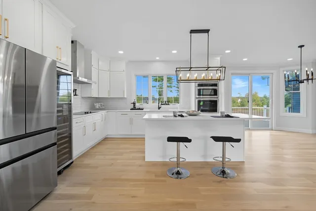 a kitchen with stainless steel appliances kitchen island granite countertop a refrigerator oven a sink and a island