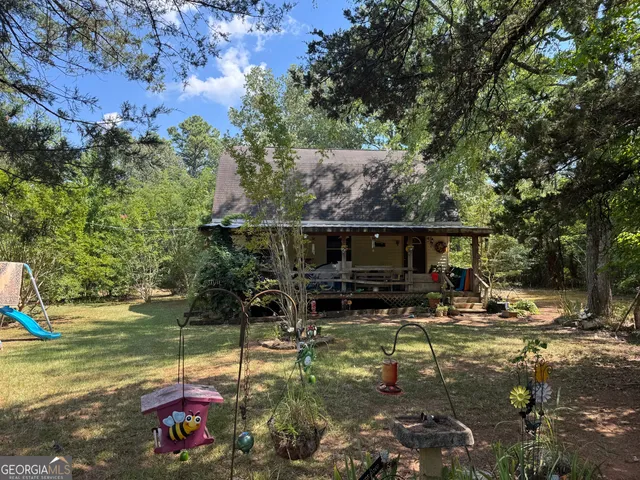 a backyard of a house with yard table and chairs
