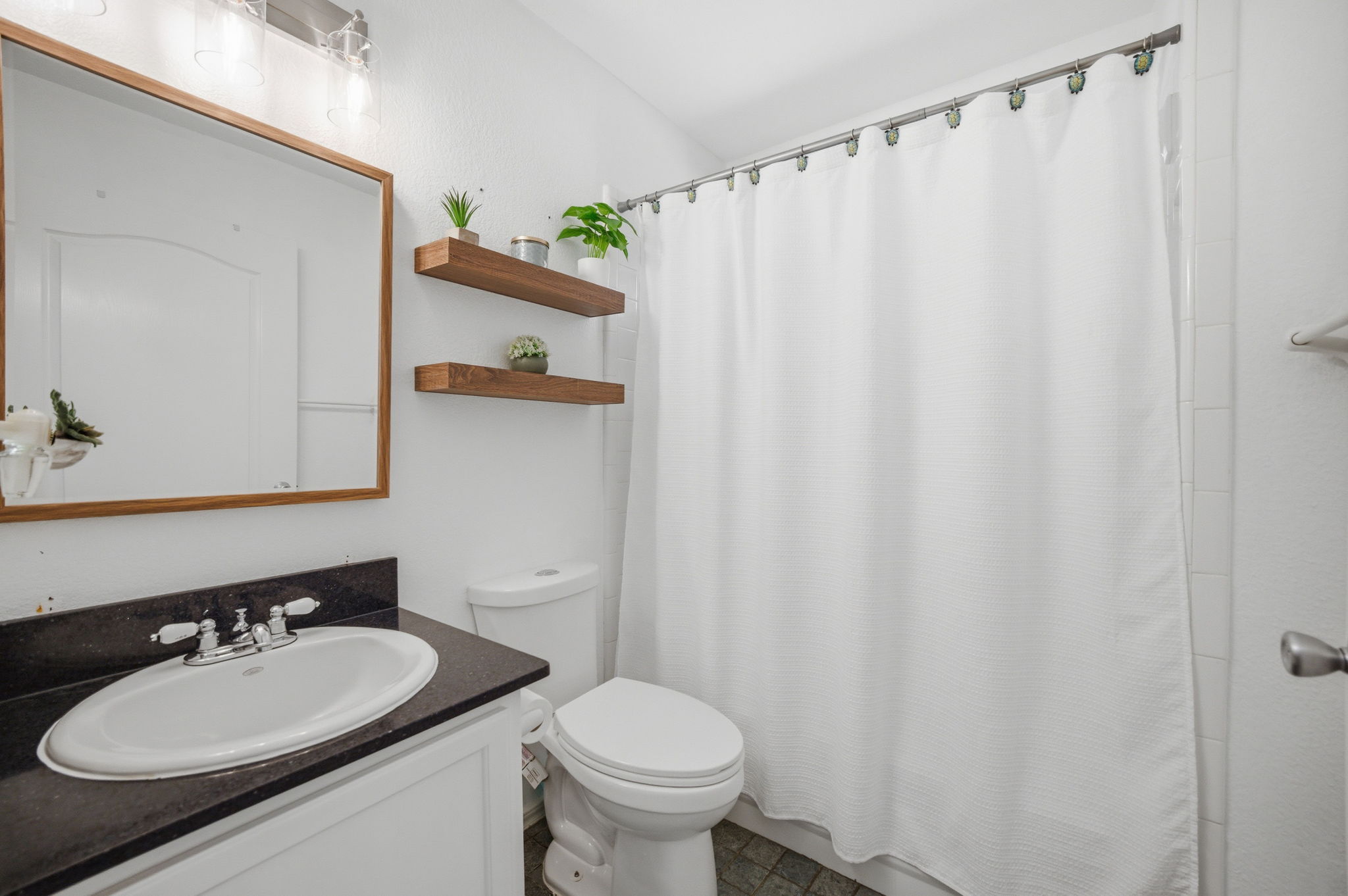 9024 Heiden Lane Austin, TX 78749 - Photo 13 of 28 Bathroom featuring a white vanity with dark countertop, an oval undermount sink, and a framed mirror