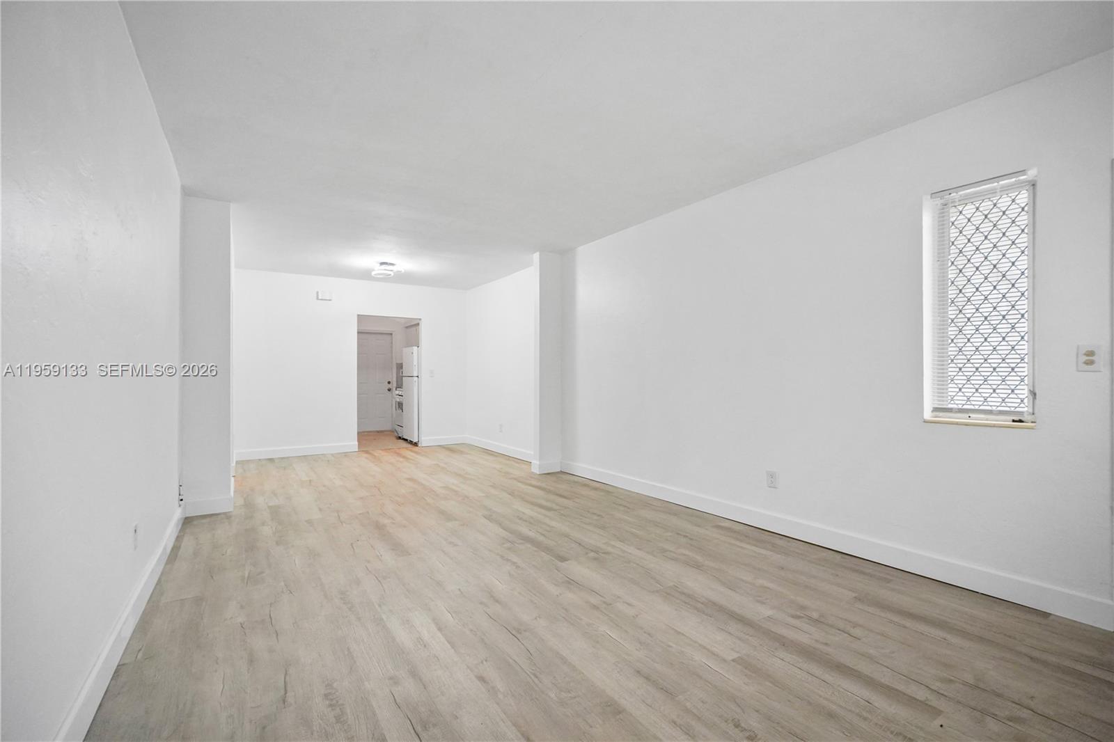 710 82nd Street, Unit 4 Miami Beach, FL 33141 - Photo 11 of 33 a view of an empty room with wooden floor and a window
