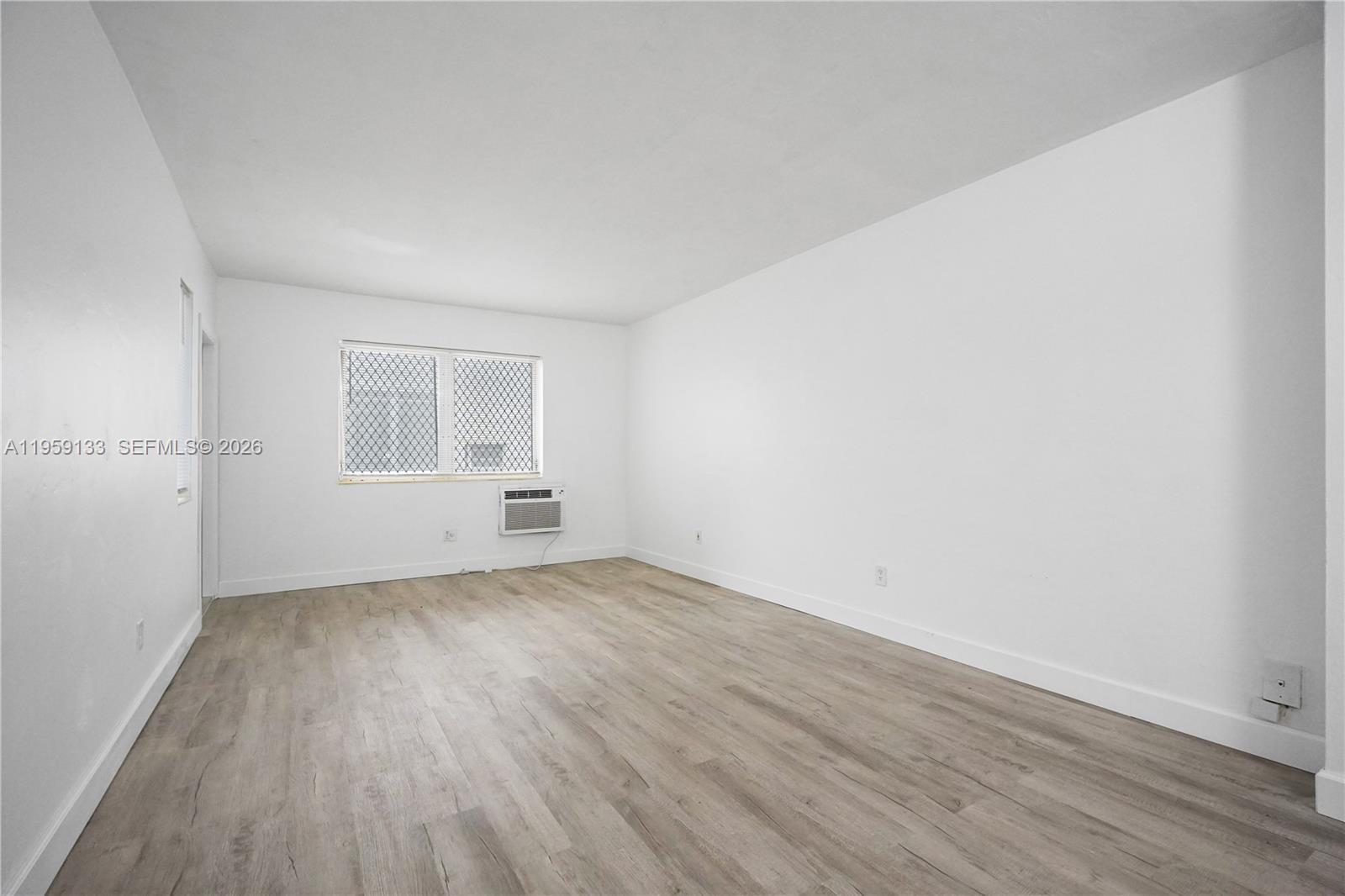 710 82nd Street, Unit 4 Miami Beach, FL 33141 - Photo 12 of 33 an empty room with wooden floor and windows
