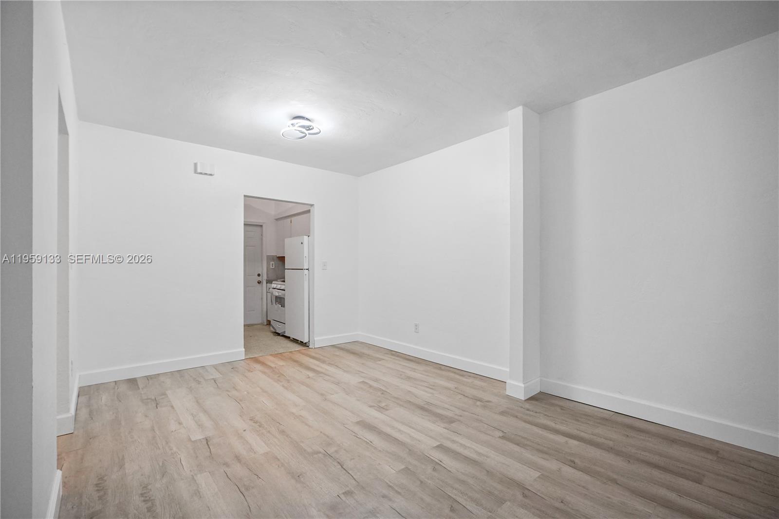 710 82nd Street, Unit 4 Miami Beach, FL 33141 - Photo 14 of 33 a view of an empty room with wooden floor and a window