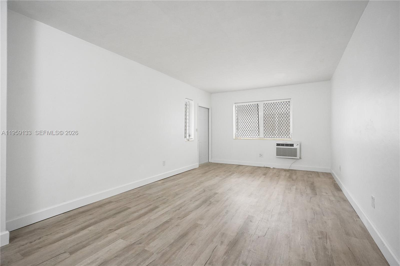 710 82nd Street, Unit 4 Miami Beach, FL 33141 - Photo 16 of 33 an empty room with wooden floor and windows