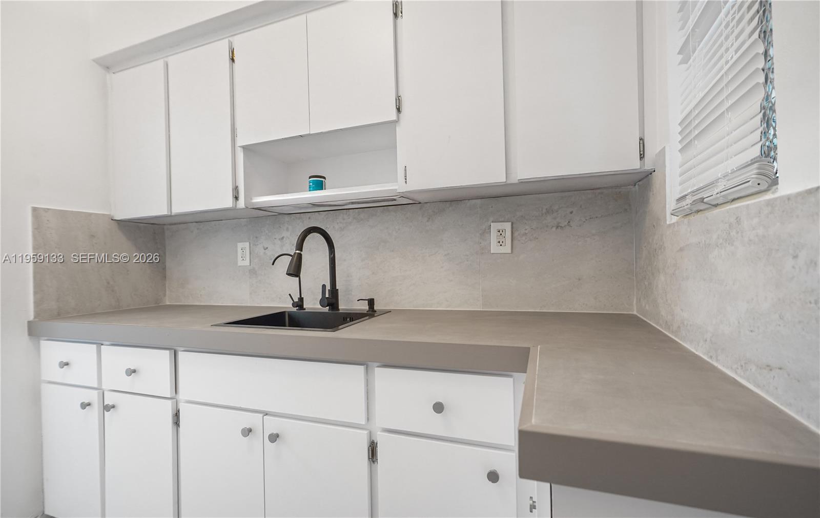 710 82nd Street, Unit 4 Miami Beach, FL 33141 - Photo 2 of 33 a kitchen with white cabinets and a sink