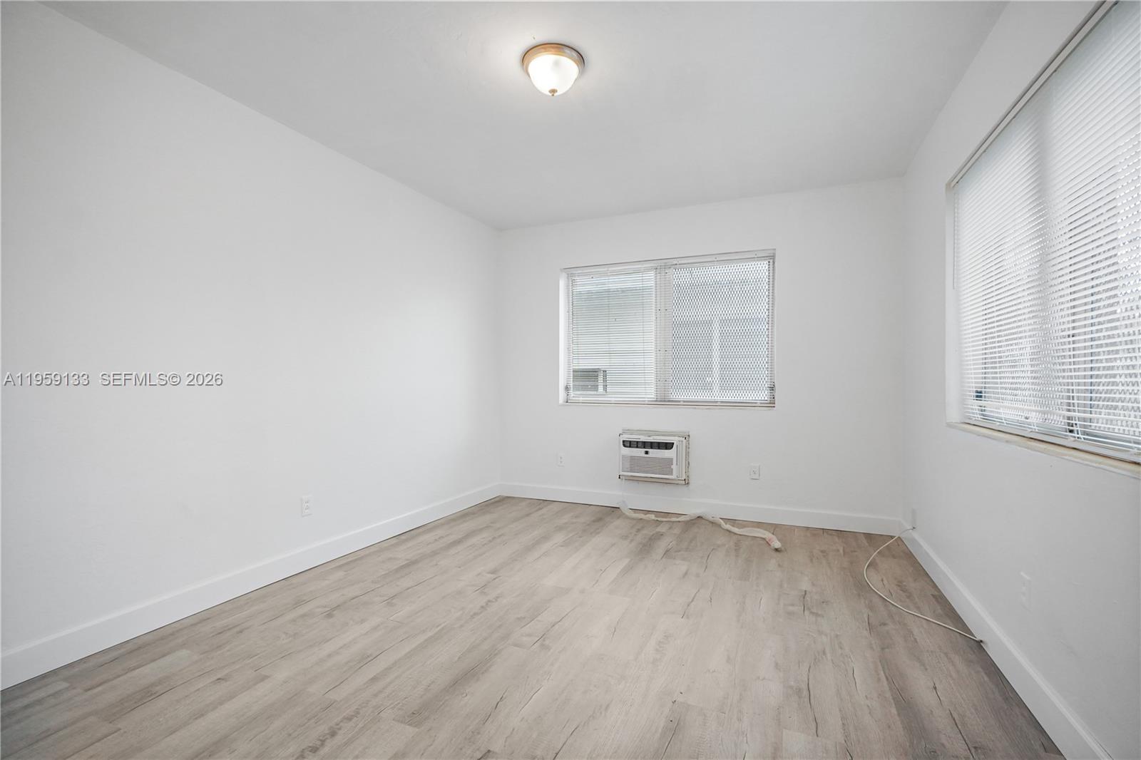 710 82nd Street, Unit 4 Miami Beach, FL 33141 - Photo 21 of 33 an empty room with wooden floor and windows