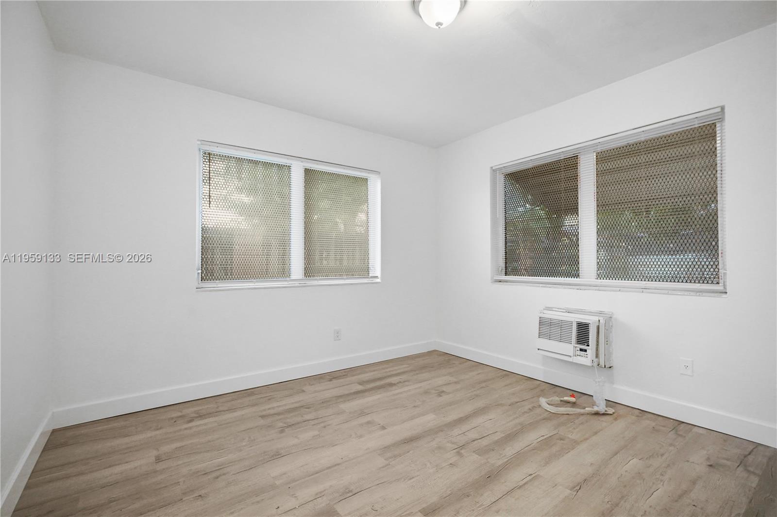 710 82nd Street, Unit 4 Miami Beach, FL 33141 - Photo 26 of 33 a view of an empty room with wooden floor and a window
