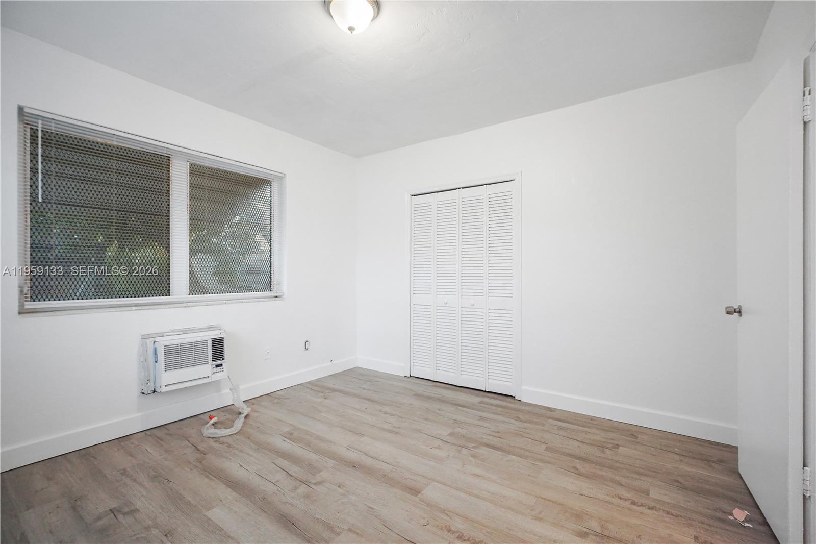 710 82nd Street, Unit 4 Miami Beach, FL 33141 - Photo 27 of 33 an empty room with wooden floor and windows