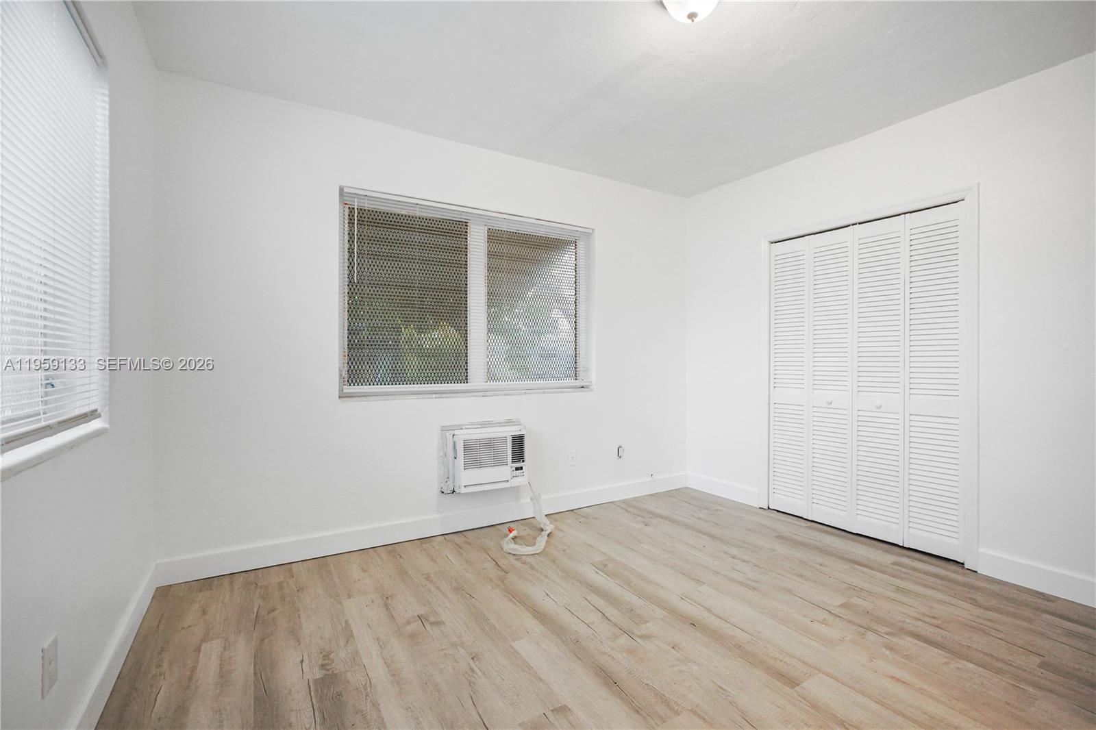 710 82nd Street, Unit 4 Miami Beach, FL 33141 - Photo 28 of 33 an empty room with wooden floor and windows