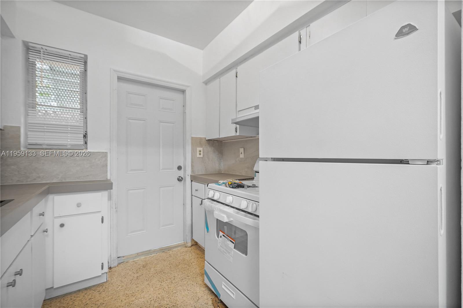 710 82nd Street, Unit 4 Miami Beach, FL 33141 - Photo 3 of 33 a kitchen with white cabinets and white appliances