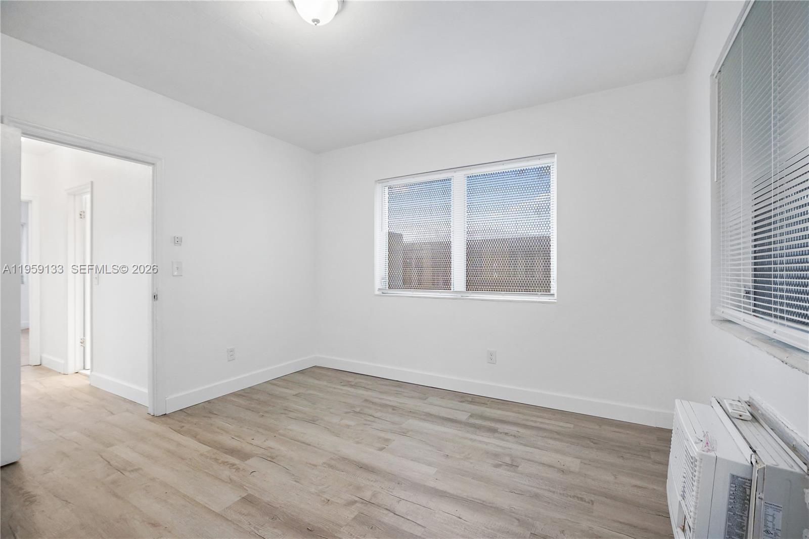 710 82nd Street, Unit 4 Miami Beach, FL 33141 - Photo 31 of 33 a view of an empty room with wooden floor and a window