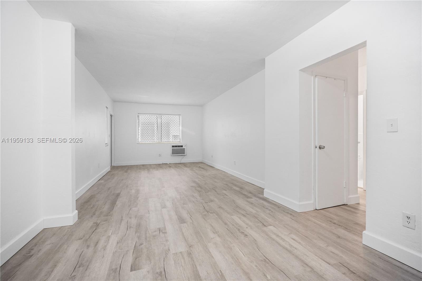 710 82nd Street, Unit 4 Miami Beach, FL 33141 - Photo 6 of 33 an empty room with wooden floor and windows