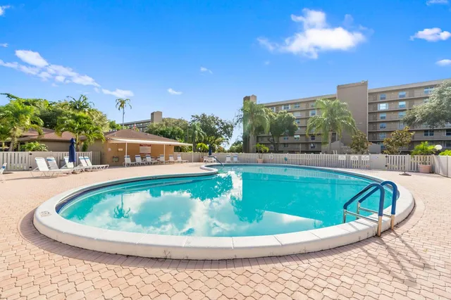 a view of swimming pool with outdoor seating and city in the background
