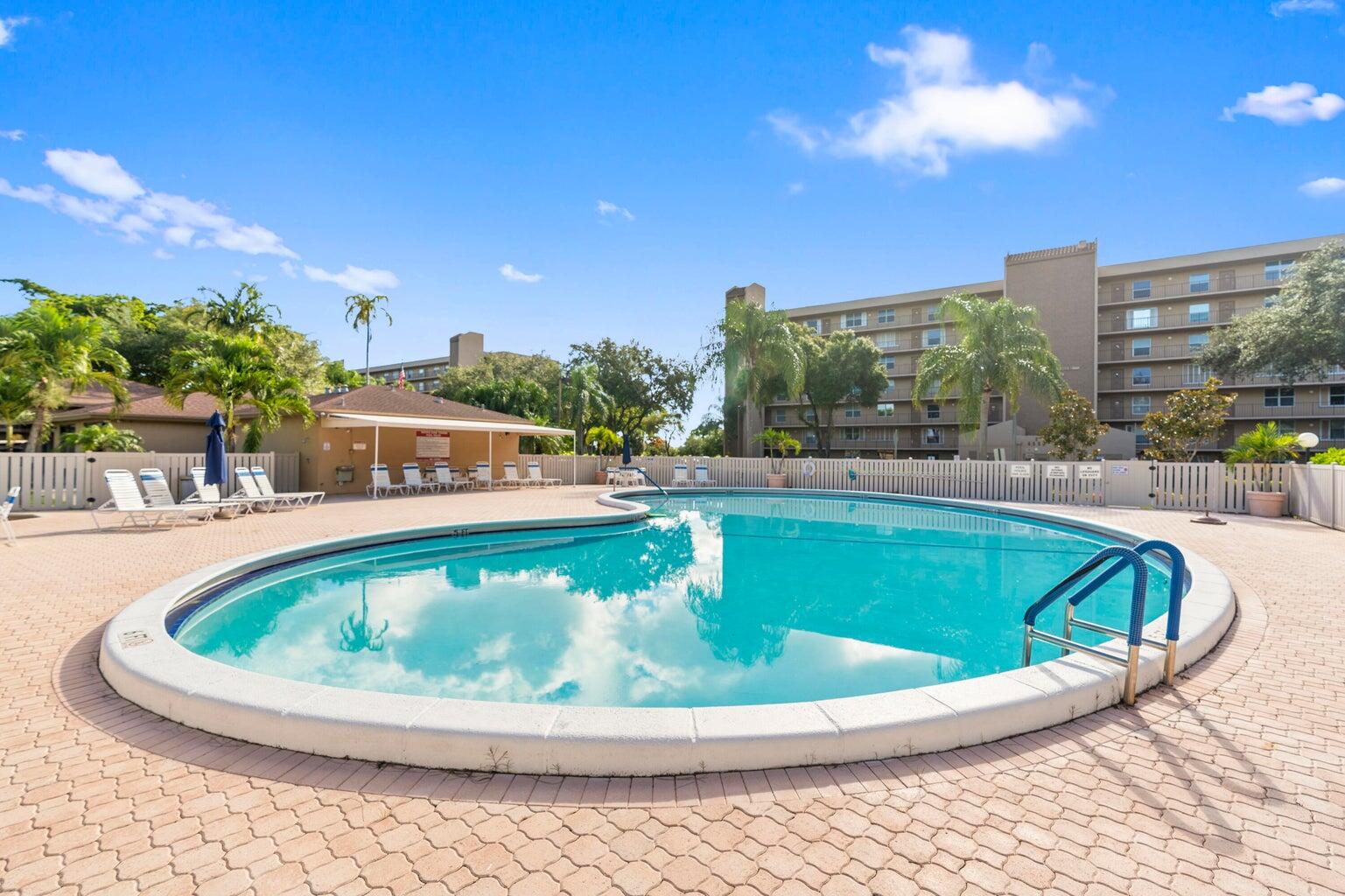 a view of swimming pool with outdoor seating and city in the background