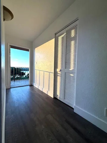 a view of wooden floor and a chandelier fan in a room