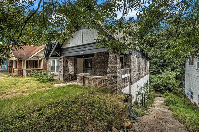 a view of house with a yard and sitting area