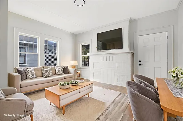 a living room with furniture a flat screen tv and a window