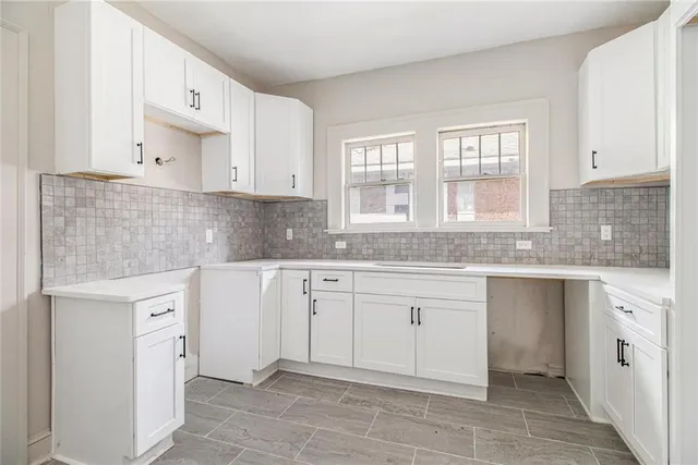 a kitchen with granite countertop white cabinets white appliances with a sink and dishwasher