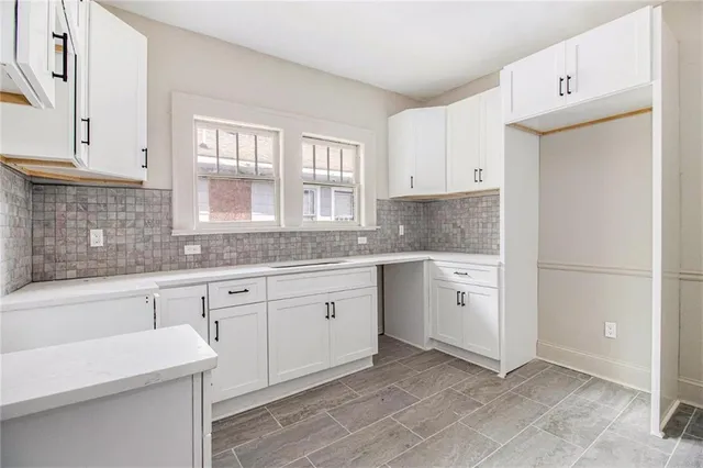 a kitchen with granite countertop white cabinets and white appliances