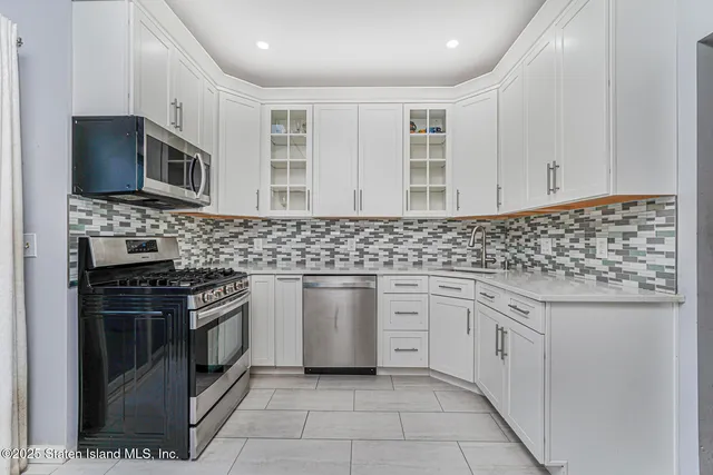 a kitchen with stainless steel appliances granite countertop a stove sink and cabinets