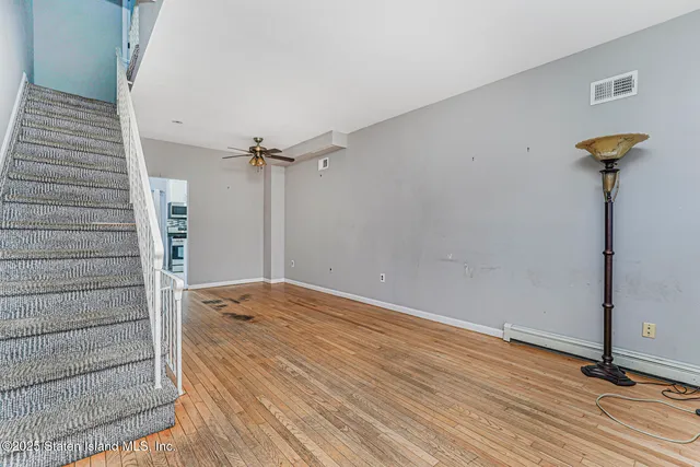a view of empty room with wooden floor