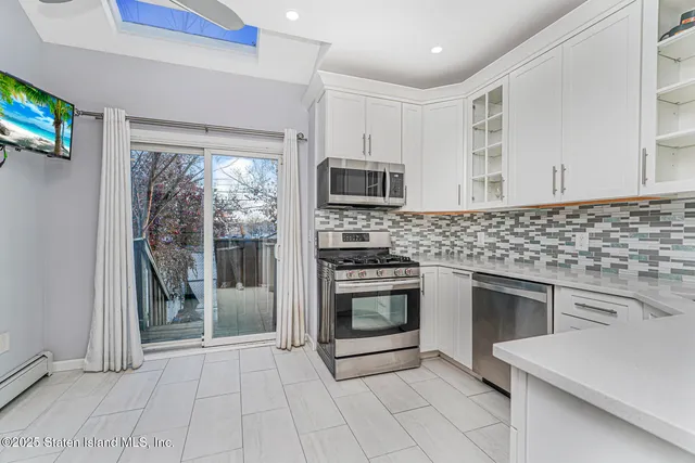 a kitchen with granite countertop a stove top oven microwave and a sink